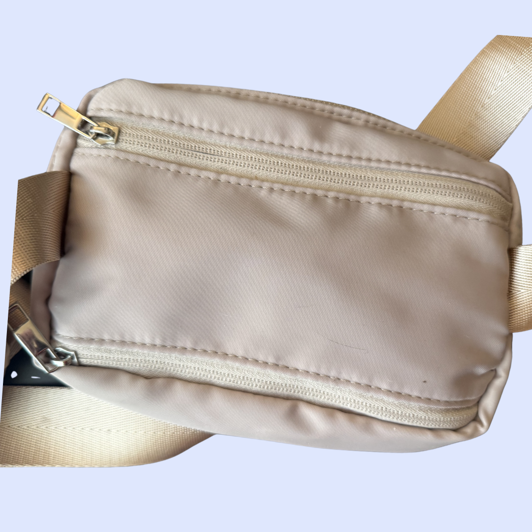 Gros plan du sac banane beige et de sa sangle