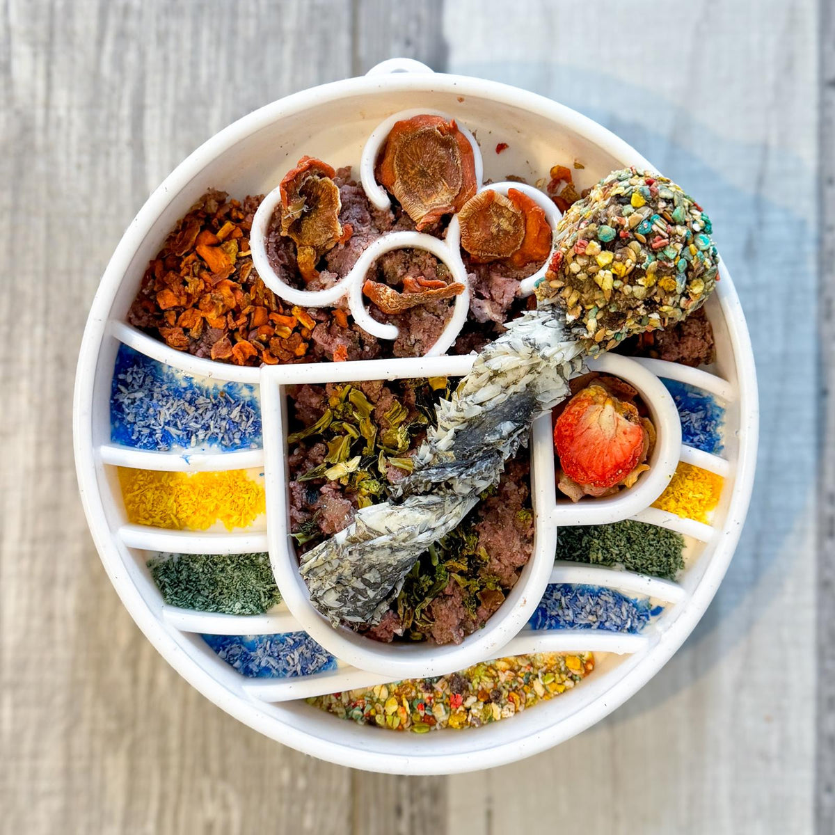 Assiette ronde compartimentée garnie de friandises et poudres colorées