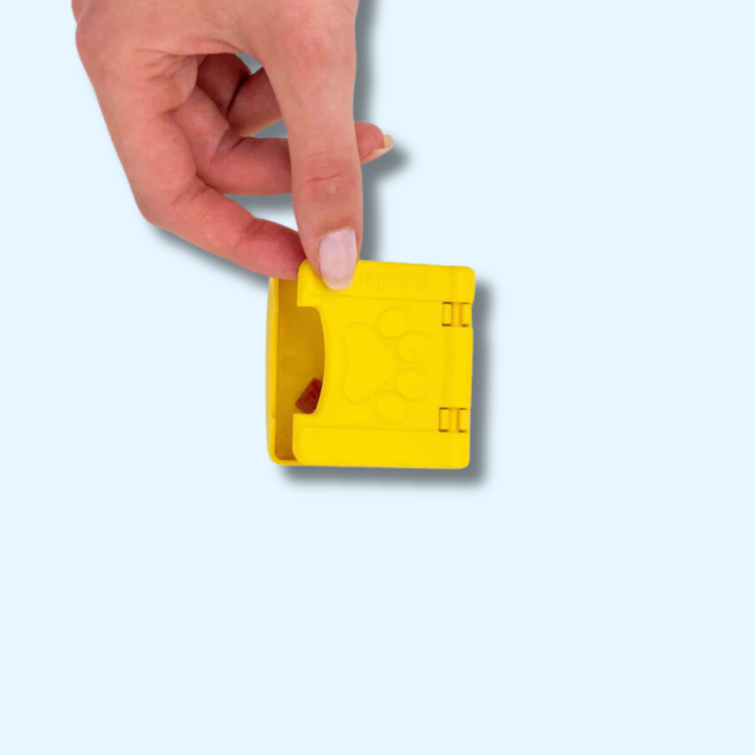 Main soulevant le clapet jaune pour cacher une friandise