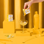 Main versant la boisson dans une coupe, décor jaune