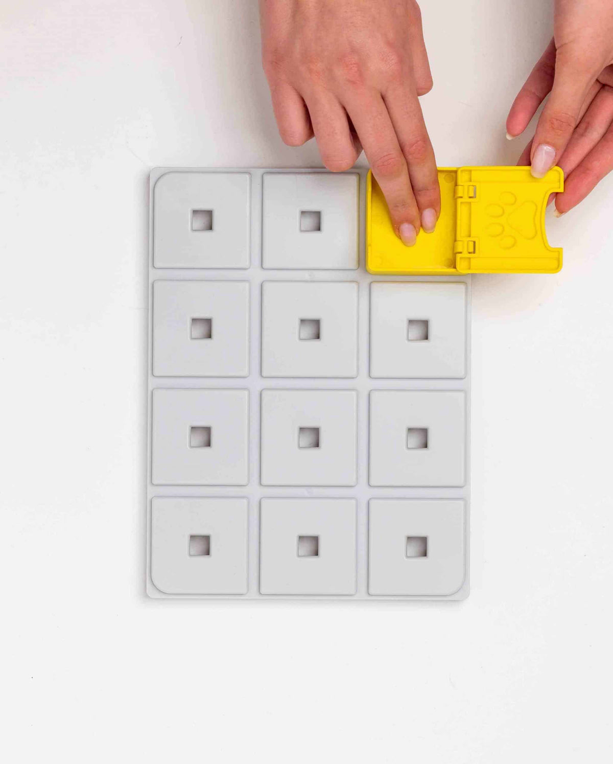 Mains clipsant un module jaune sur le plateau gris