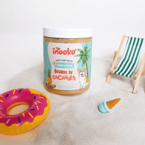 Pot turquoise inooko sur le sable, bouée donut et transat