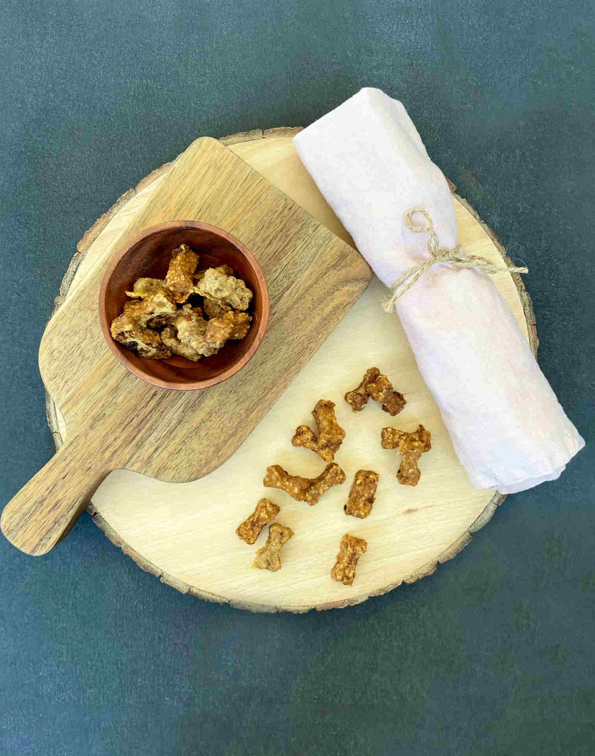Friandises training Fresco en forme de petits os sur une planche en bois et dans un bol