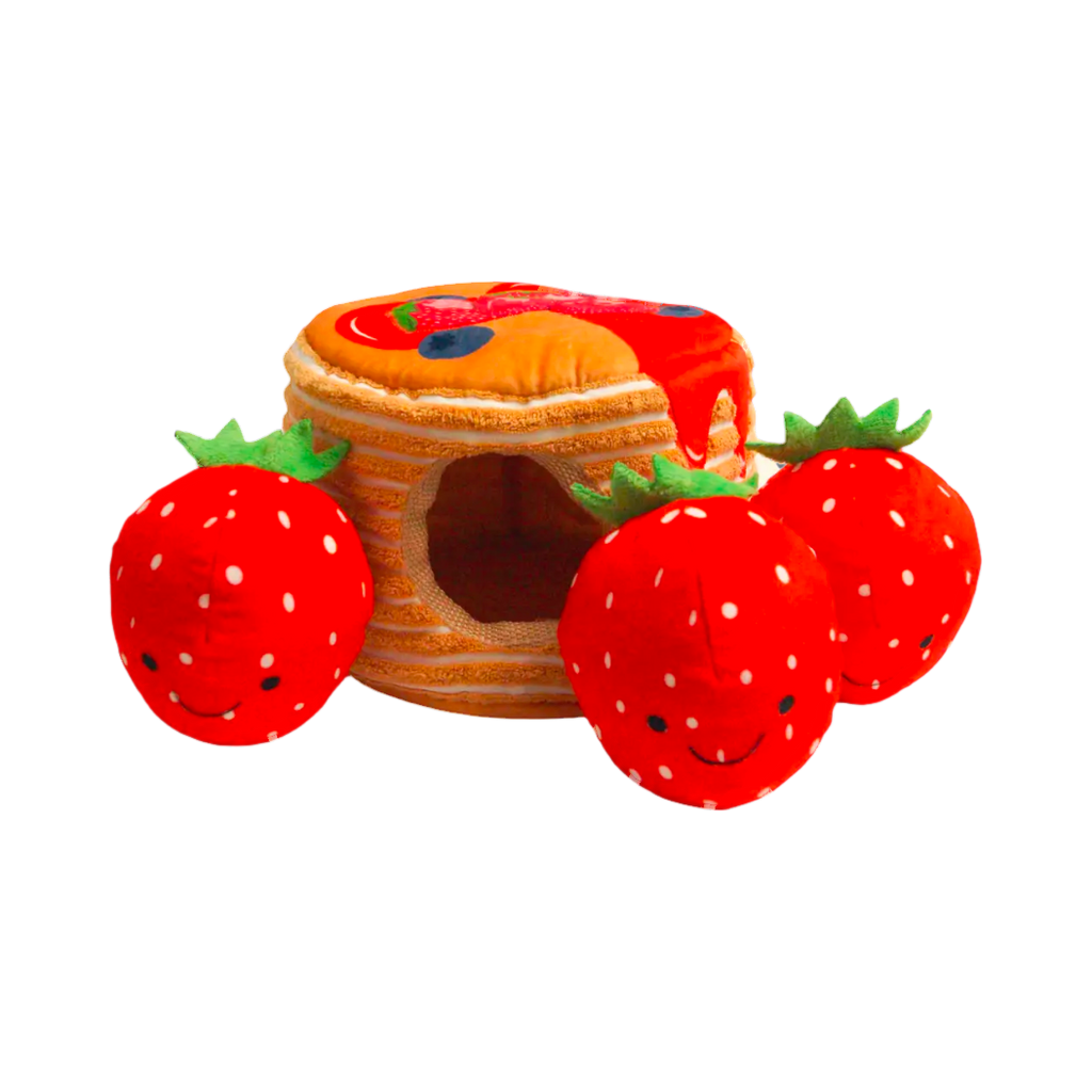 Pile de pancakes nappée avec trois fraises rouges souriantes
