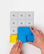 Mains assemblant un disque bleu et un bloc jaune sur le support