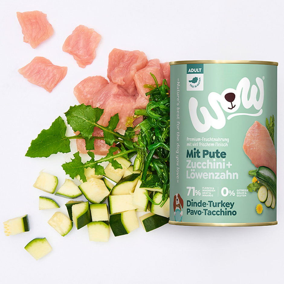 Boîte de pâtée WOW dinde, courgettes & pissenlits entourée de ses ingrédients