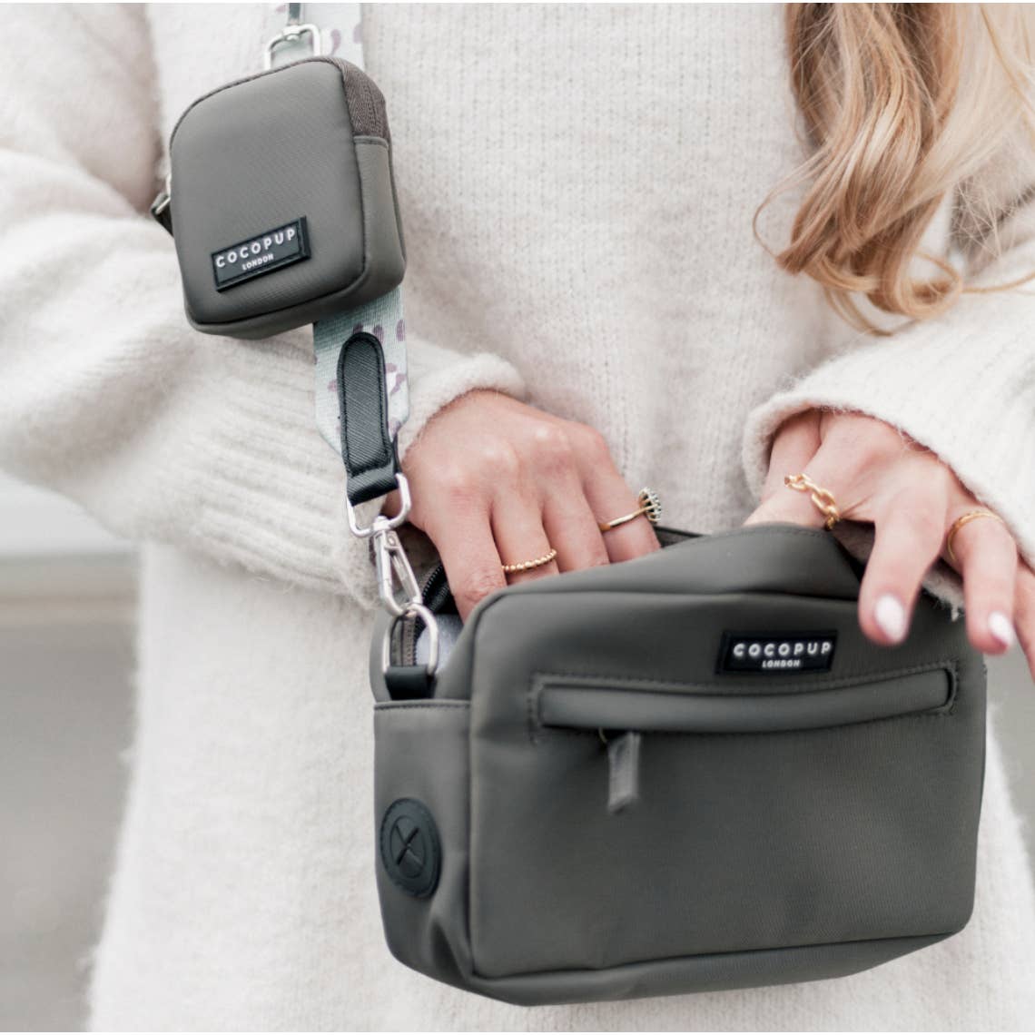 Femme en pull blanc portant le sac gris en bandoulière