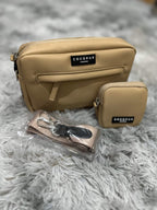 Sac camel et pochette assortie posés sur une fourrure